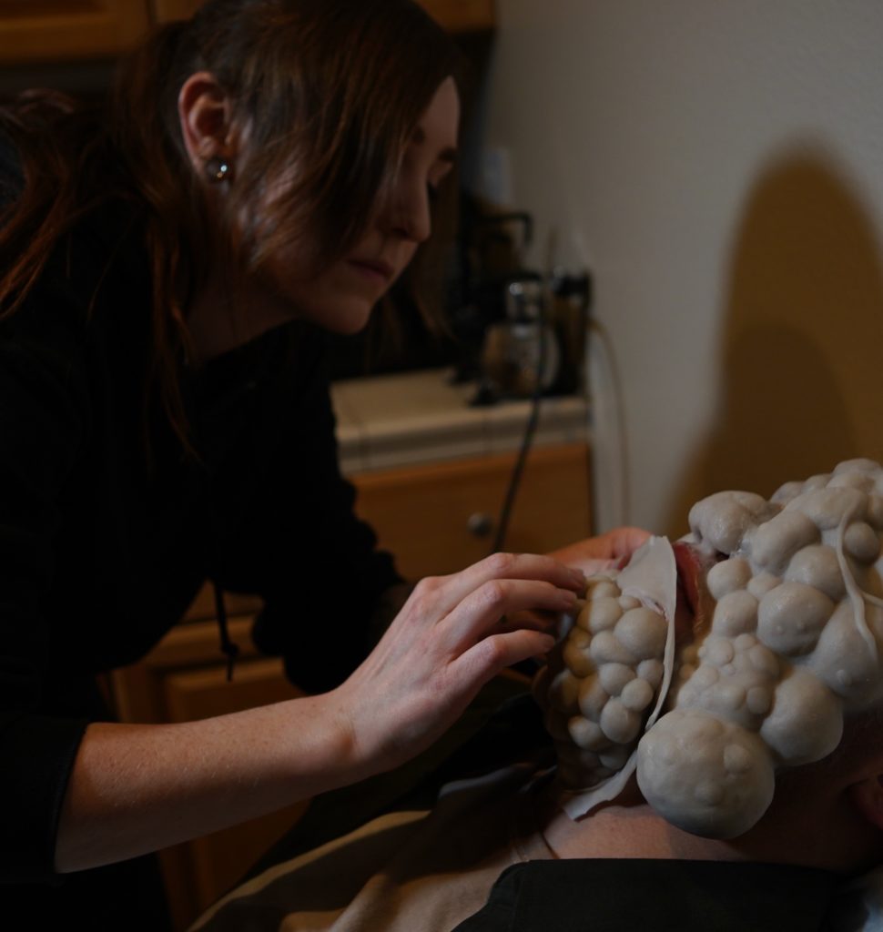 Special Effects artist Lauren Bennett applying large bumpy silicone prosthetics to her Left 4 Dead Smoker makeup.